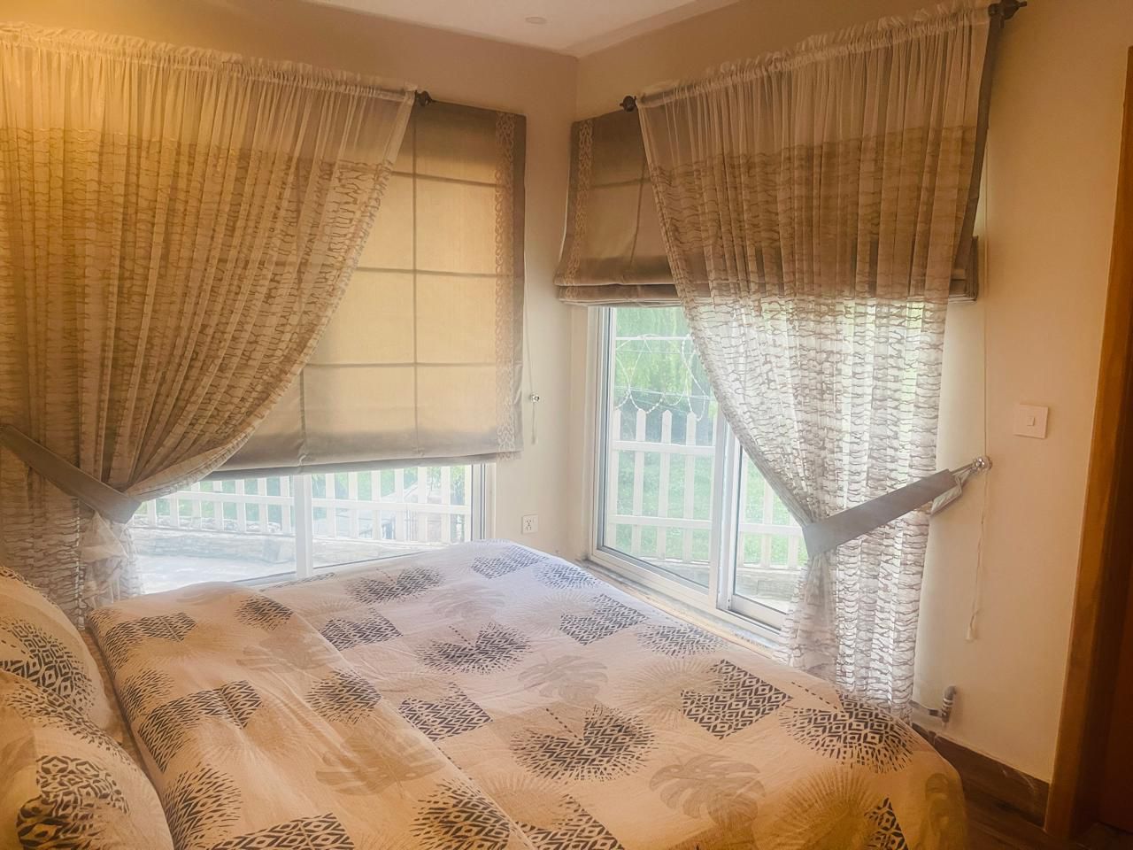 sunlit cottage lounge with large panoramic windows, mountain views, modern comfortable seating, natural light flooding interior, elegant furniture